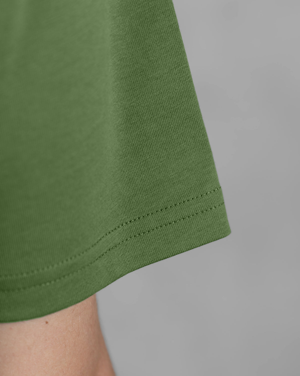 Detail des grünen XTRACTD Basic T-Shirts in Coffee Leaf mit Stoffstruktur und Ärmelnaht
