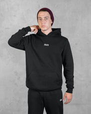 XTRACTD Hoodie Rebellion in Espresso Black – Model in Vorderansicht, Hand am Nacken