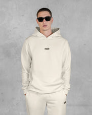 XTRACTD Hoodie Rebellion in Oat Milk – Model mit Sonnenbrille, Vorderansicht, Hoodie mit kleinem Logo auf der Brust