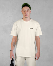 XTRACTD T-Shirt Rebellion in Oat Milk – Model trägt T-Shirt, Vorderansicht mit Brust-Logo
